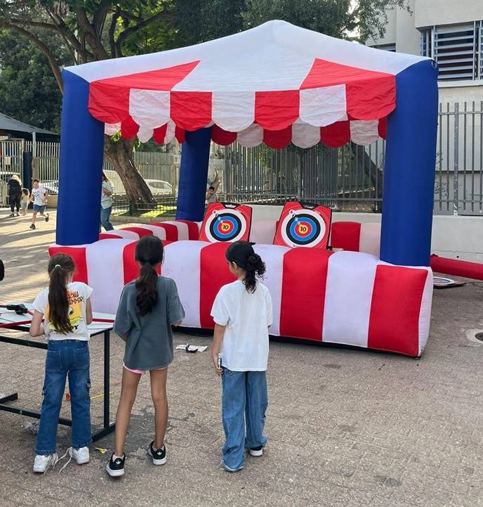 3 ילדים משחקים קליעה למטרה בדוכן מתנפח, צילום" אילן אזולאי