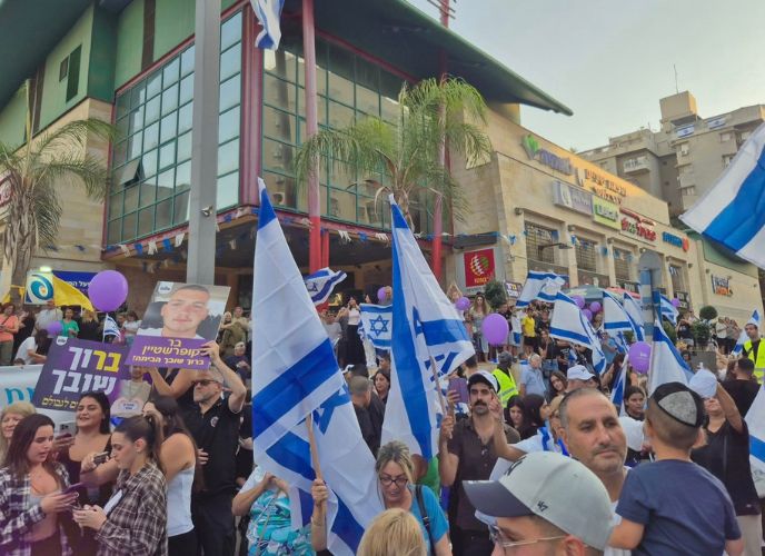 תושבי חולון עם דגלי ישראל ושלטים מקבלים את פנוי של בר קופרשטיין, צילום: עיריית חולון