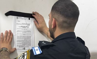 שוטר מדביק על דלת דירה צו סגירה מנהלי, צילום: משטרה